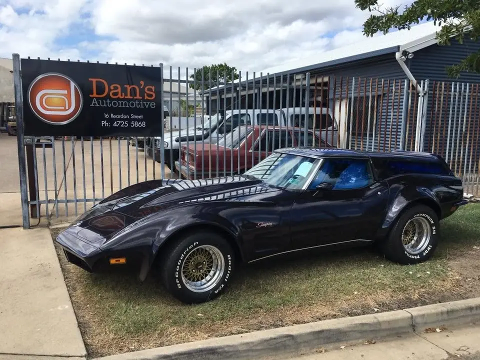 Black Chevrolet Corvette parked outside the Dan's Automotive signage