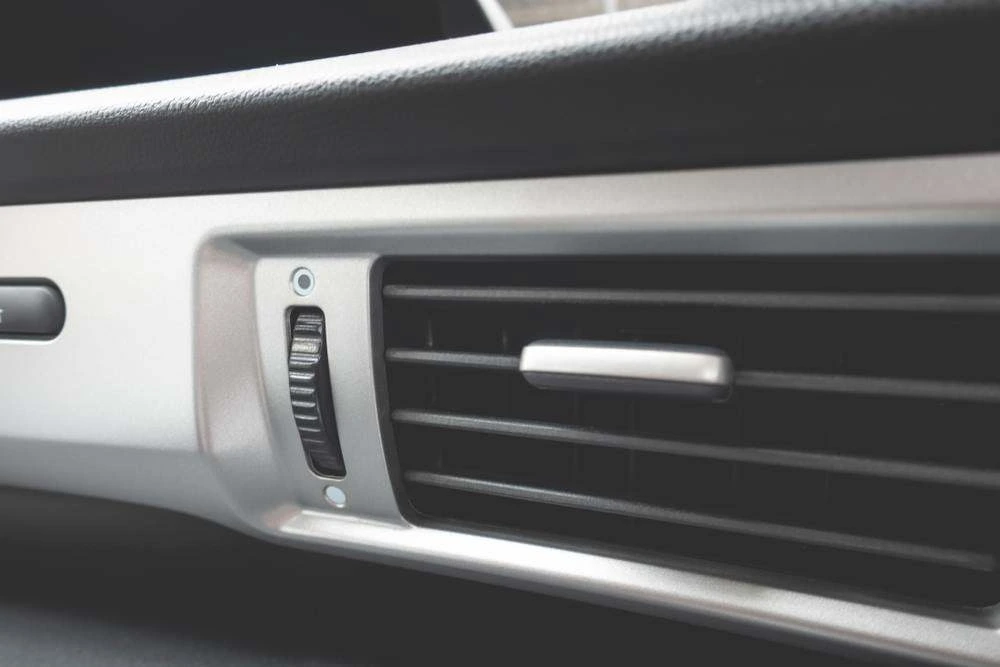 Close-up of a car dashboard air conditioning vent and control dial