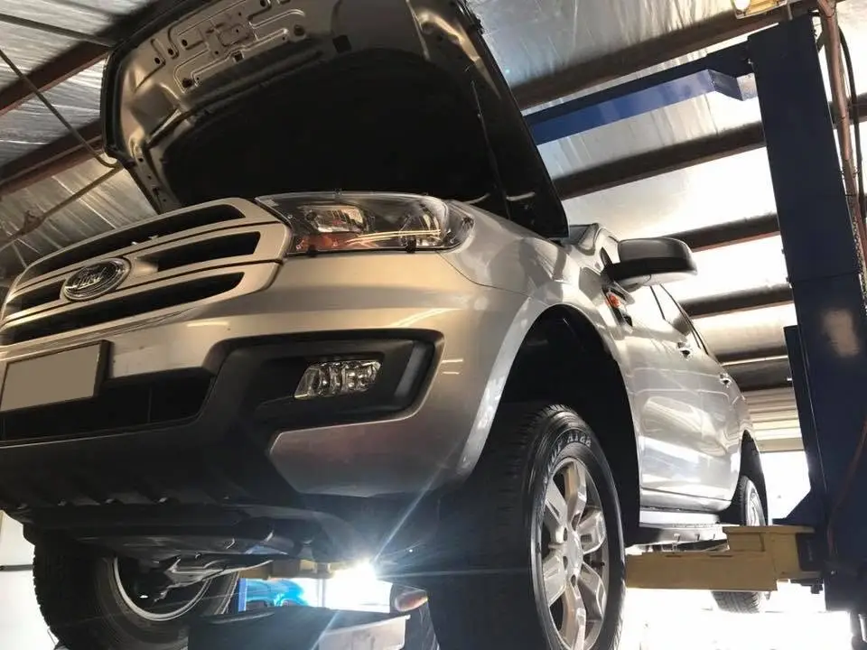 Silver SUV on a hoist with its bonnet up in the Dan's Automotive workshop